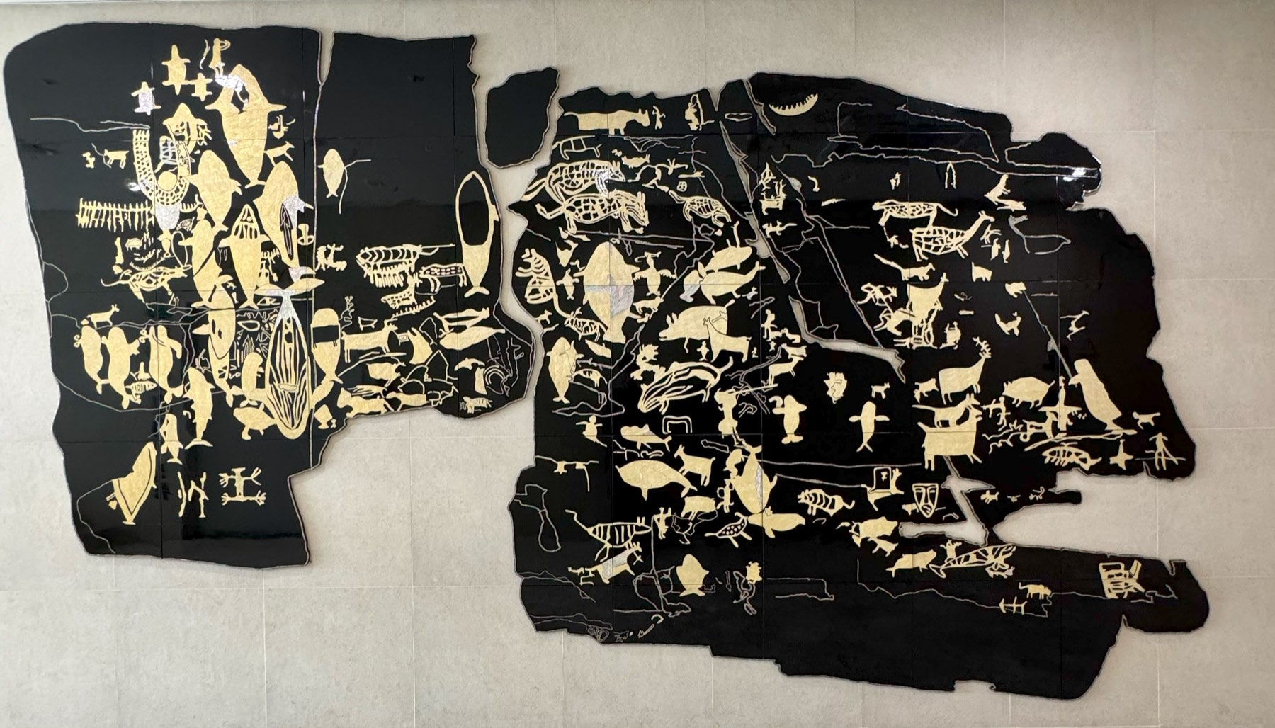 A black-and-cream reproduction mapping every carved figure on the rock panel