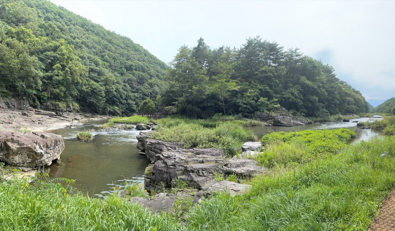 The Daegokcheon Stream winding between green hills and rock ledges