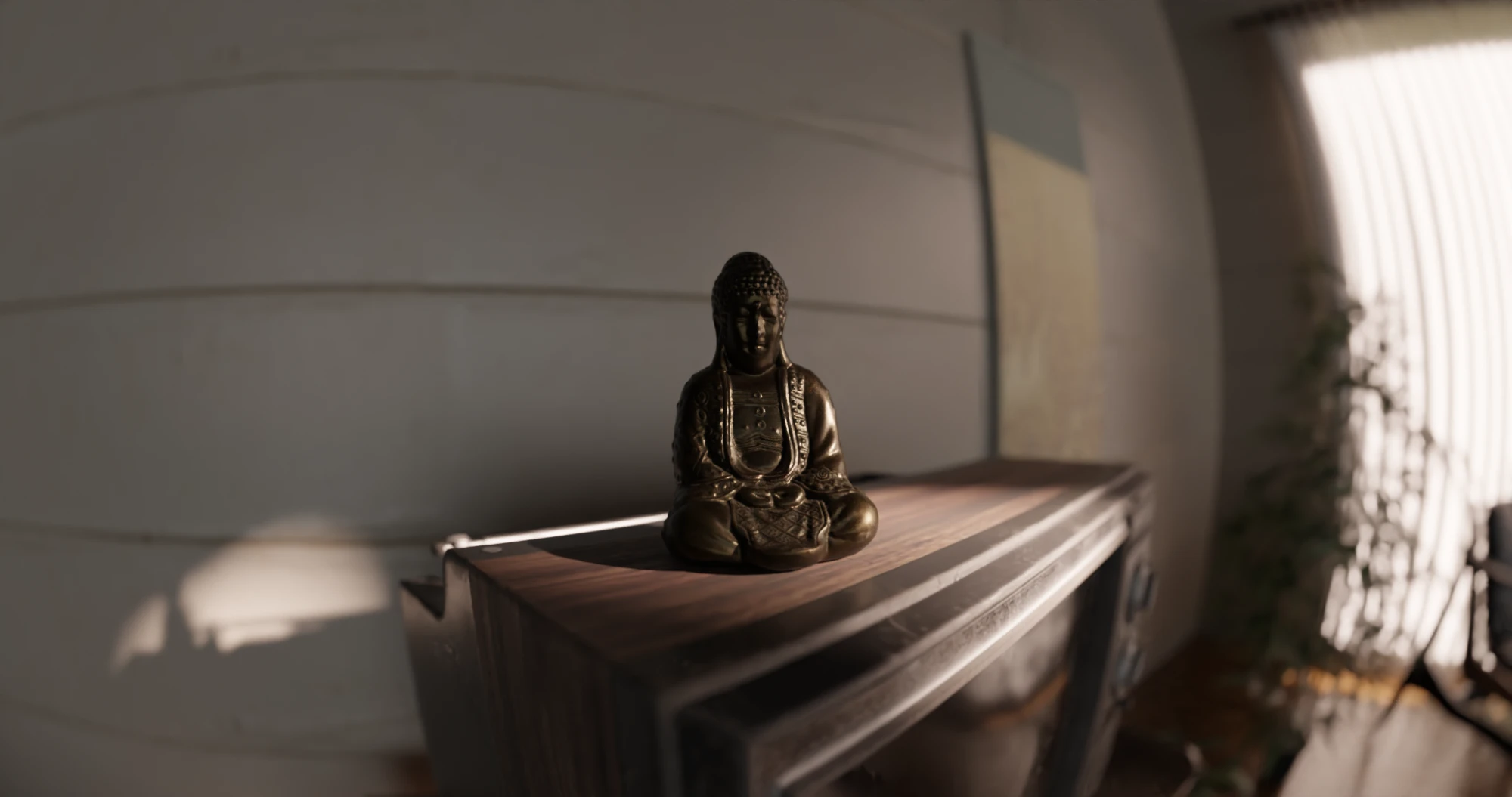 A small bronze Buddha on top of the vintage television, catching a slant of sun