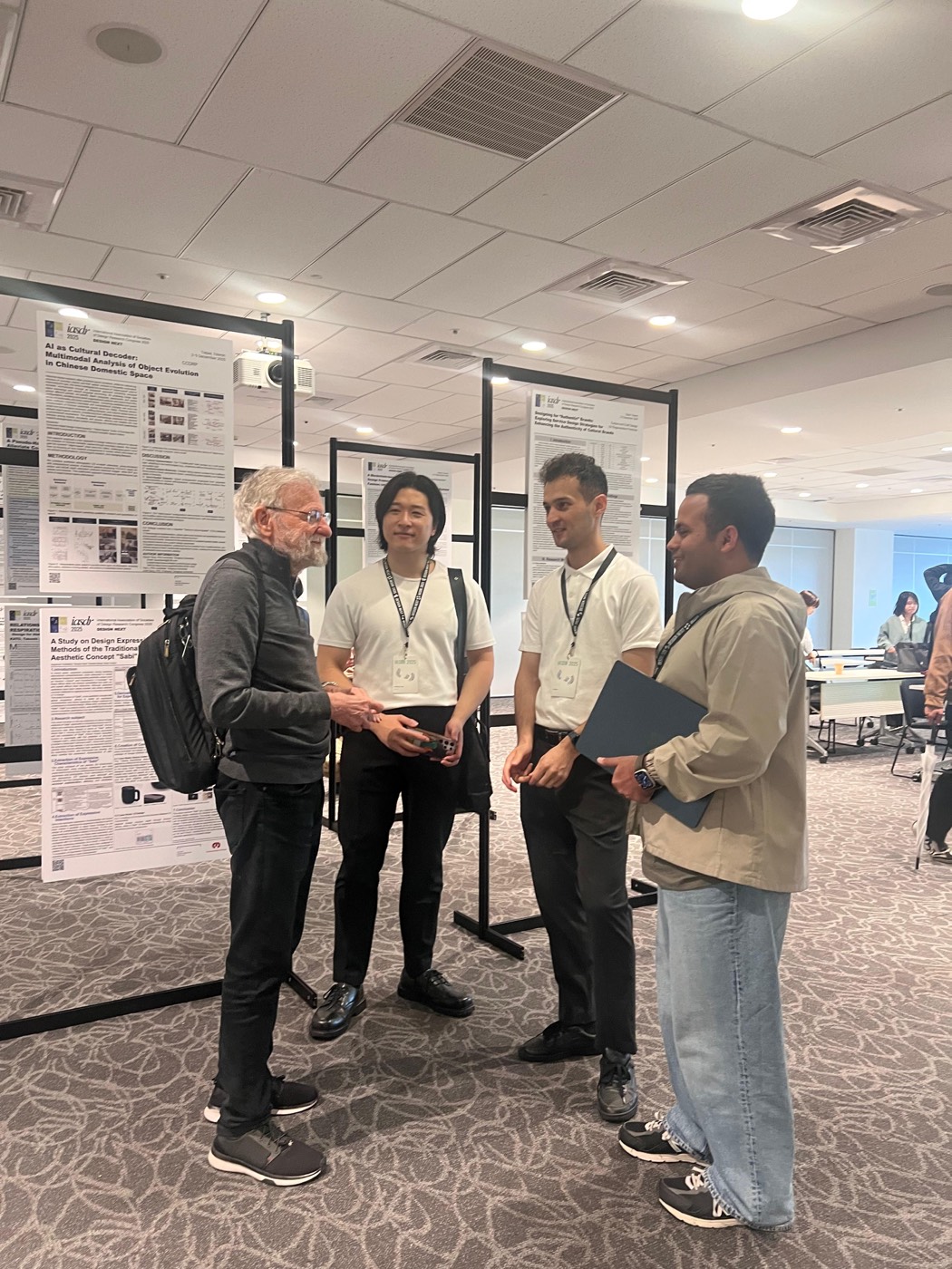 Four people in conversation at a conference poster session